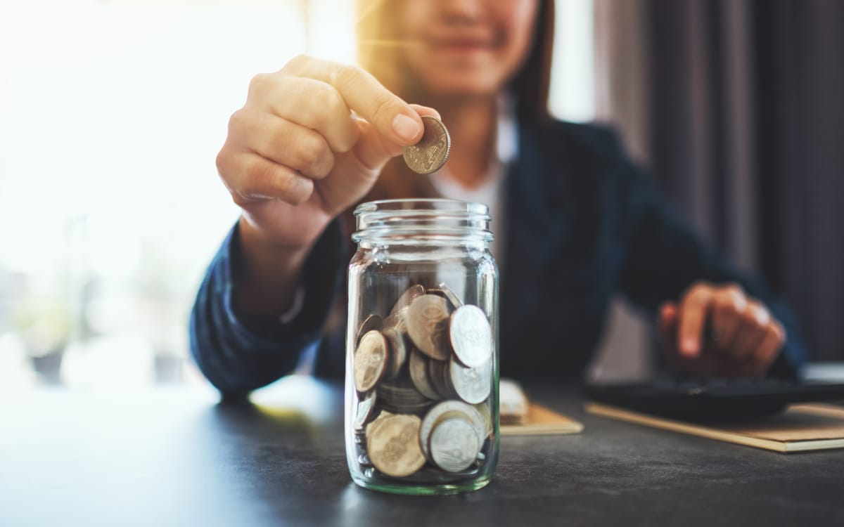 Closeup Image Of A Businesswoman Collecting And Putting Coins In A Glass Jar