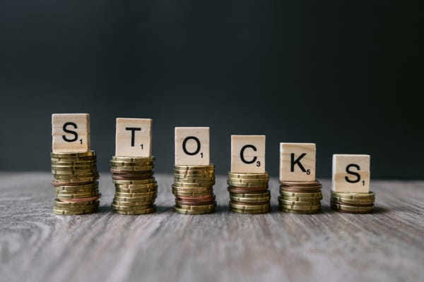 The word Stocks on decreasing coins. Concept for falling stock markets